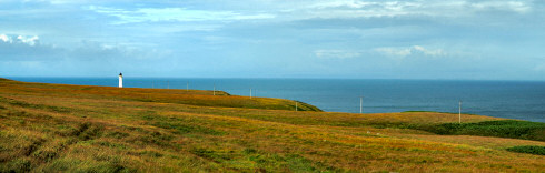 Picture of a wide landscape with telegraph poles leading to a lighthouse in the distance