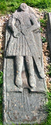 Picture of a grave slab of a warrior with his sword, carving of a birlinn at this feet