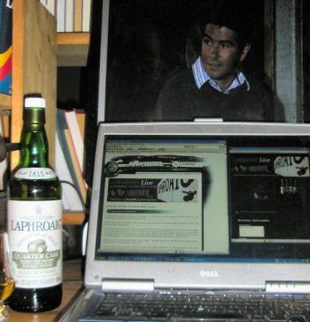 Picture of a laptop and an external monitor set up to watch the Laphroaig Live webcast, John Campbell on screen