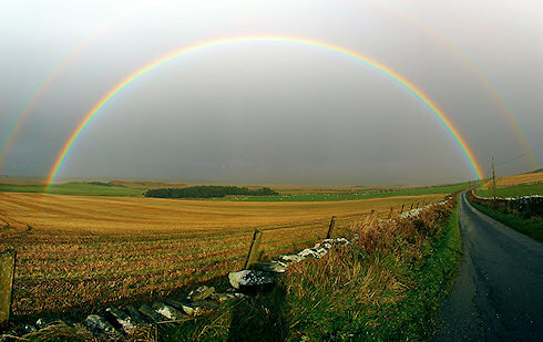 Picture of a full rainbow over an agricultural landscape