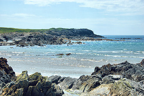 Picture of a mostly rocky bay with only a few small waves coming in
