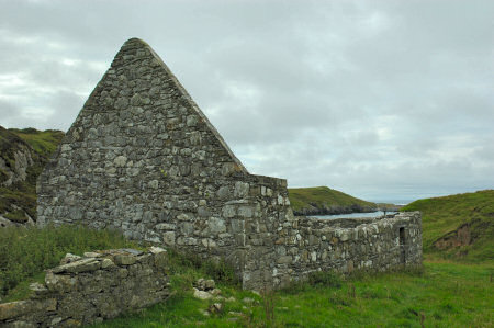 Picture of the ruins of a chapel, a bay in the background