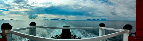 Picture of a panoramic view looking back from a ferry over three islands