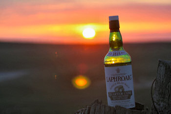 Picture of a whisky bottle in the last sunlight during a sunset