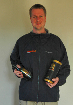 Picture of Armin wearing a jacket with a Bunnahabhain logo, holding a Bunnahabhain bottle