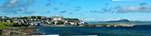 Picture of a panoramic view over a coastal village (Bowmore on the Isle of Islay) with a small pier and harbour