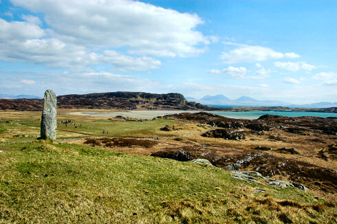 Picture of a view from a small hill over an island, two other islands in the distance