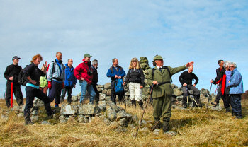 Picture of a gamekeeper with a group of walkers, pointing out a feature