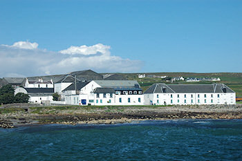 Picture of white washed distillery buildings at a sea shore (Bruichladdich distillery on the Isle of Islay