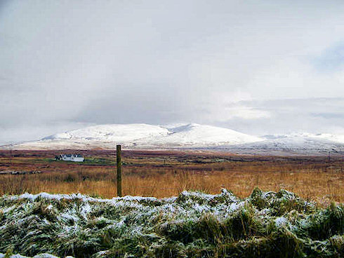 Picture of a frosty winter landscape with snow covered hills in the distance