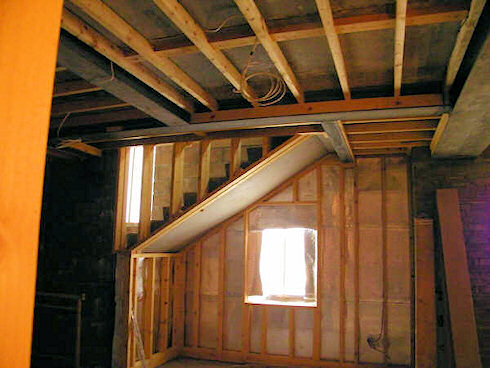Picture of a room with ongoing building work, stairs can be seen in the back