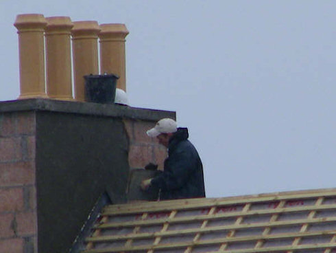 Picture of a builder plastering a chimney head