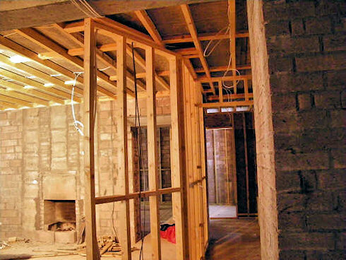 Picture of a room with building work under way, a fireplace and the frame for a wall can be seen