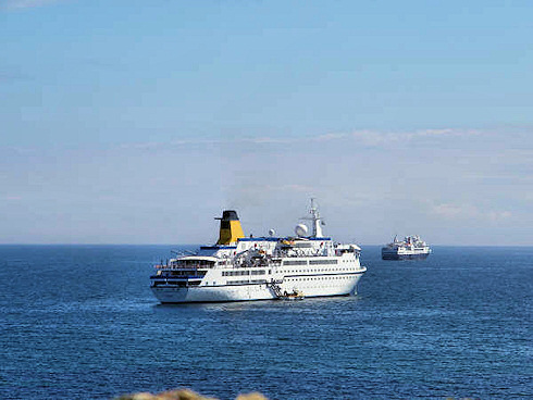 Picture of two cruise ships anchored off an island