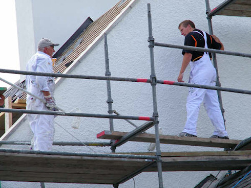Picture of two men painting a gable end standing on scaffolding