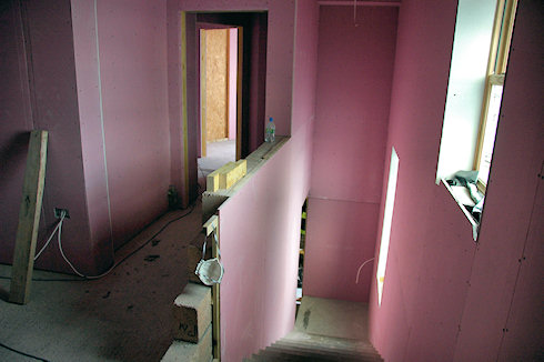 Picture of the stairs and landing of an under construction hotel, the plasterboard in a nice pale pink