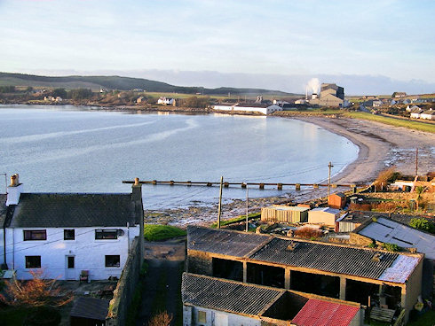 Picture of a view over a bay with distillery warehouses and a maltings at the end