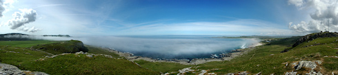 Small panoramic picture of a sea bay with the haar (sea fog) rolling in