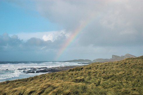 Picture of a partial rainbow over a stormy bay