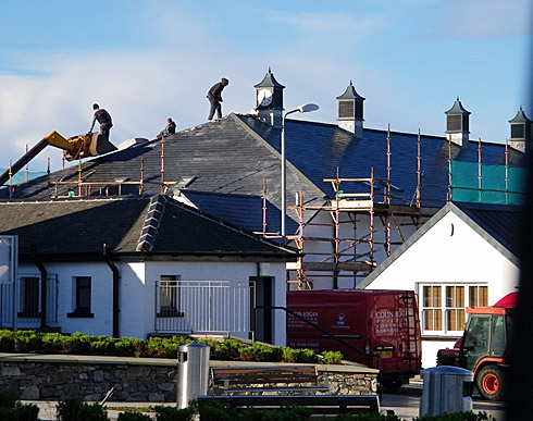 Picture of a leisure centre with workmen on the roof