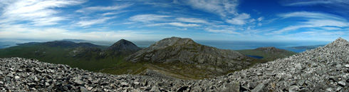 Small picture of a panoramic view from the top of a mountain over two other mountains