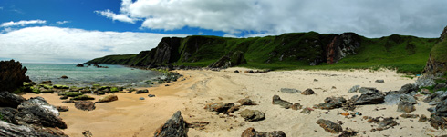 Panoramic picture of a cove with a beach and waterfall