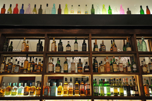 Picture of the shelves behind a bar with lots of whisky bottles