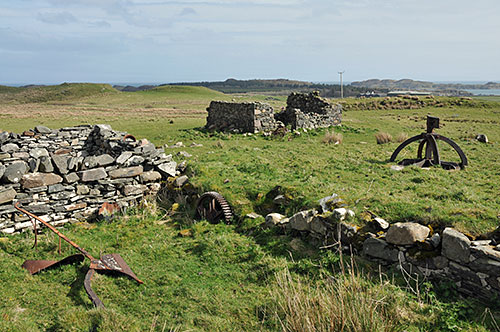 Picture of ruined farm buildings with some rusting machinery