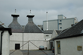 Picture of old distillery buildings with a modern malting towering over it