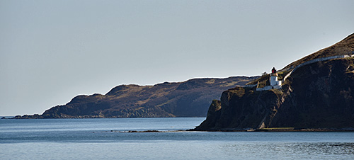 Picture of a lighthouse and a coastline on a calm sunny afternoon
