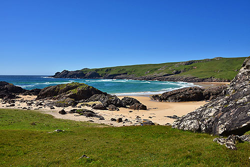 Picture of a bay with a sandy beach in front of grassy dunes