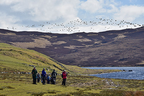 Picture of a group of walkers next to a loch
